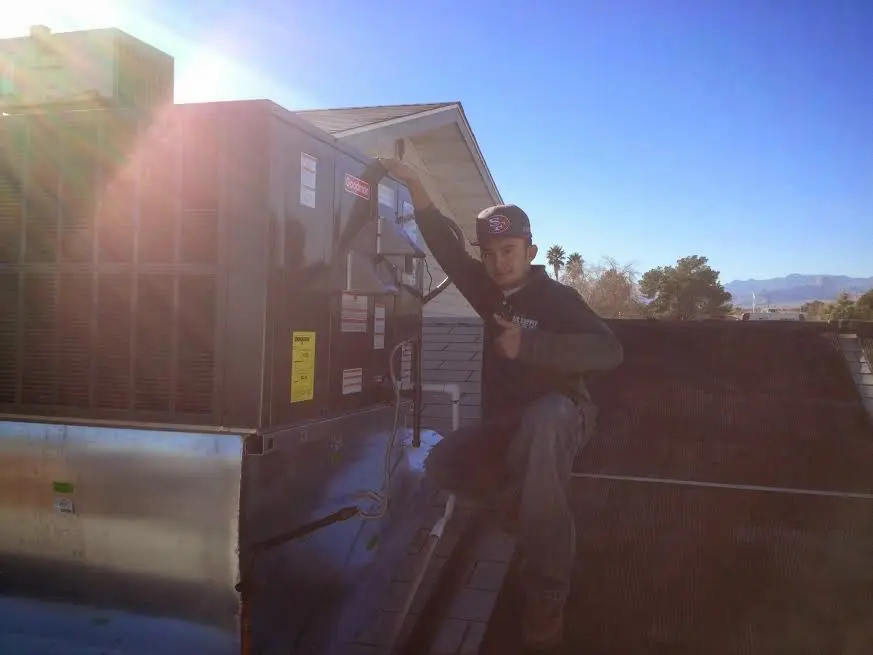 HVAC technician performing Air Duct Repair on a rooftop unit in Northfield